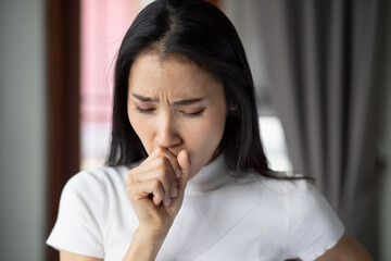 Fototapeta na wymiar Sick dry coughing asian woman staying home indoor, concept of coronavirus symptomatic infection, lockdown, social distancing, new normal lifestyle of pre coronavirus cure, COVID-19 vaccine