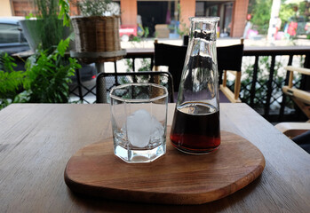 Pouring cold brewed coffee on a glass of ice cube
