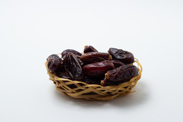 Dates on a white background. Dried fruits. Dried dates are in a small basket