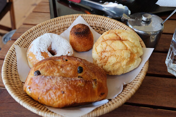 Basket of Japanese Melon bun, Coconut Roche, Sugar icing donut and sweet raisin bun