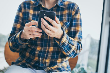 using cell phone hand holding mobile texting message contact us.chatting,search internet information in office.technology device communication connecting