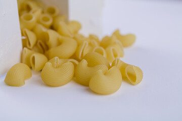 Italian durum wheat pasta poured from a white box on the table