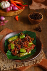 vegetables cooked with sambal and special herbs named andaliman, on an earthenware plate 