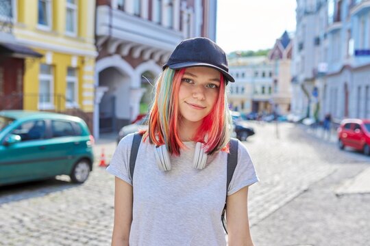 Portrait of fashionable smiling hipster teenage girl with colored dyed hair in black cap