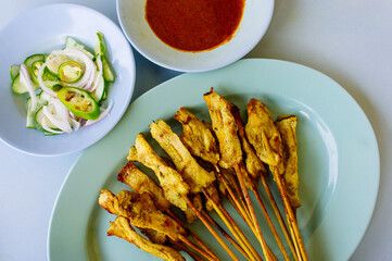 grilled pork satay with peanut sauce and vinegar on table
