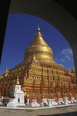 Naklejka premium Shwezigon Pagoda, one of the oldest and most impressive monuments of Bagan, Myanmar. Most noticeable is the huge gold plated pagoda glimmering in the sun.