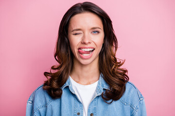 Fototapeta premium Photo of cute attractive flirty young woman bite tongue wink eye isolated on pastel pink color background