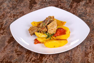 Baked pork meat with potao and tomato