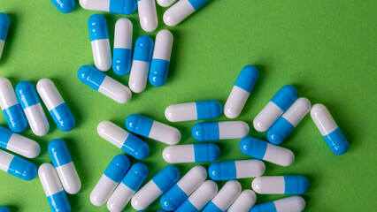white and blue pills on yellow background