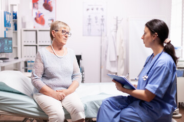 Fototapeta premium Healthcare nurse telling senior woman diagnosis about illness. Elderly patient having a converstation with medical stuff in private clinic during consultation.