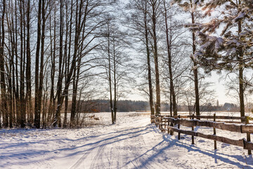 Wooden fence in a rural winter landscape.