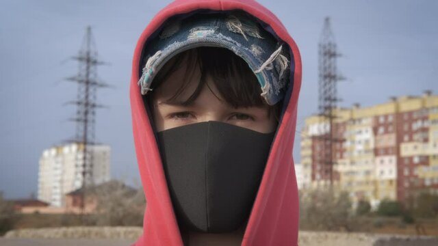 Girl and contagious disease. A young girl in a protective mask looks indifferently at the camera.