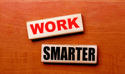 On a wooden table are two wooden blocks with the text WORK SMARTER
