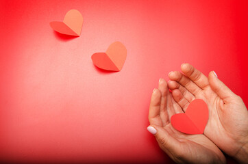 Fototapeta premium three red paper hearts on a red background