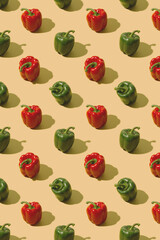 Red and green bell peppers on a pastel beige background. Creative fresh vegetables pattern.