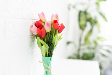 Bouquet of spring tulips with different color flowers wrapped in paper for present on white background