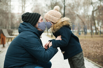 Dad and son are wearing masks.