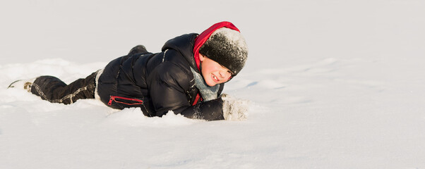 Naklejka premium Little boy playing in the snow