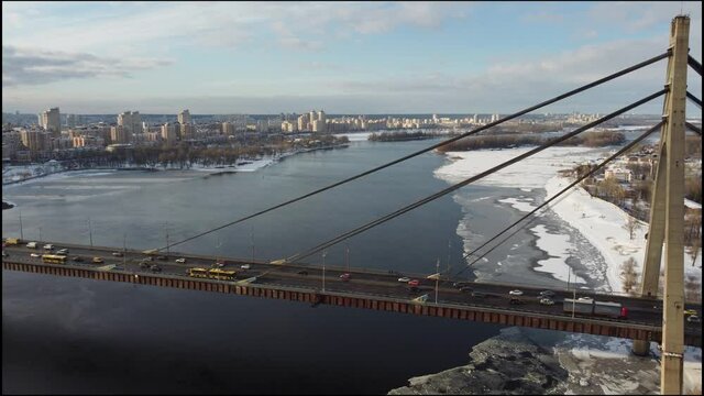 Cars cross the bridge from one bank to the other
