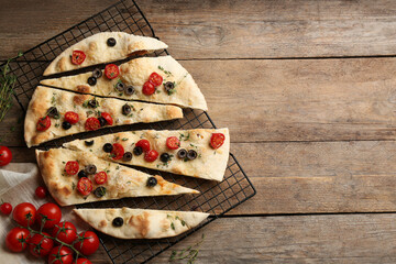 Flat lay composition with focaccia bread on wooden table. Space for text