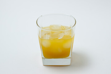 Juice with ice in a glass on a white background. Natural mango juice. Refreshing drink