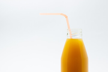 Glass bottle with juice on a white background. Natural mango juice. Refreshing drink