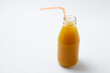 Glass bottle with juice on a white background. Natural mango juice. Refreshing drink