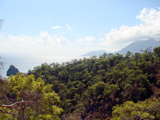 Fototapeta premium Panorama of the blue sky, which is approached by a large white cloud and almost covers the top of the mountain range.