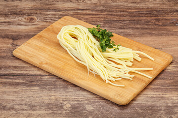 Chechil spaghetti cheese over board