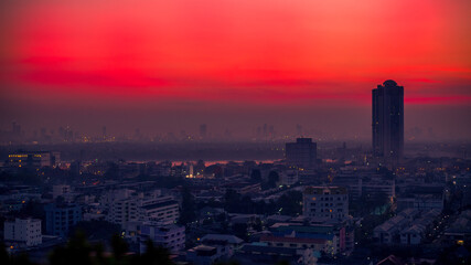 Fototapeta premium The high angle background of the city view with the secret light of the evening, blurring of night lights, showing the distribution of condominiums, dense homes in the capital community