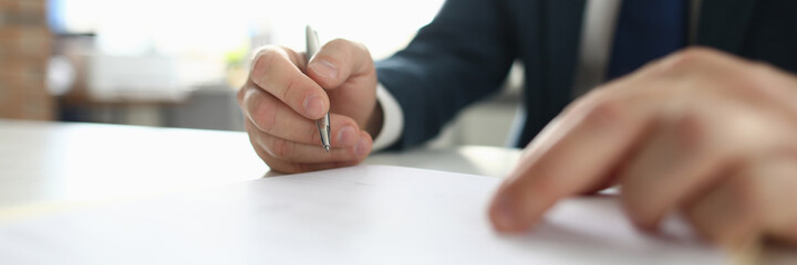 Close-up of smart businessman sitting in luxury office. Clever clerk signing agreement....