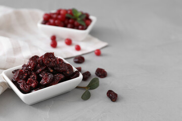 Dried and fresh cranberries on light table, space for text