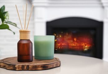 Reed air freshener and candle on table indoors. Space for text