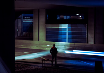 Fototapeta na wymiar man waiting for the bus under the bridge at night