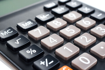 Black plastic digital calculator, isolated on a white background, close-up. Symbol economics, mathematics, accounting, finance concept. The day of knowledge, to calculate, to count money