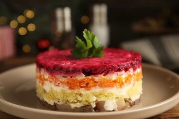 Herring under fur coat on plate, closeup. Traditional russian salad