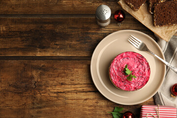 Herring under fur coat served on wooden table, flat lay with space for text. Traditional russian salad