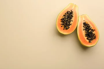 Frische halbierte Papaya-Frucht auf beigem Hintergrund, flach gelegt. Platz für Text © New Africa