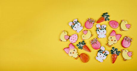 Fototapeta na wymiar Closeup of variation of different Easter sugar cookies decorated with royal icing. Eggs, bunny, carrots and chicken on yellow background. Lovely sweet gift or postcard