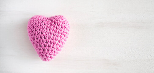 Knitted heart for Valentine's Day on a light background with copy space