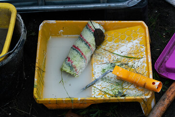 Unwashed roll of paint left in the rain. Non-organic paint in nature. Spilled paint in nature.