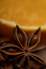 Half an orange and a star anise on a wooden table.