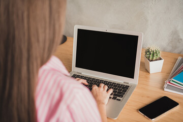 Photo of confident beautiful young lady wear pink shirt sitting table typing modern device indoors room home house