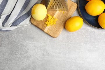 Lemon zest and fresh fruits on grey table, flat lay. Space for text