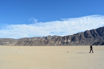 moving stones on the Racetrack Playa leaving tracks in the dry and cracked terrain in the Death Valley National Park, recflections of the sun