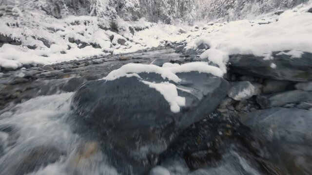 FPV Drone Flying Over Stream And Bridge Near Cascade du Rouget In France During Winter. - aerial