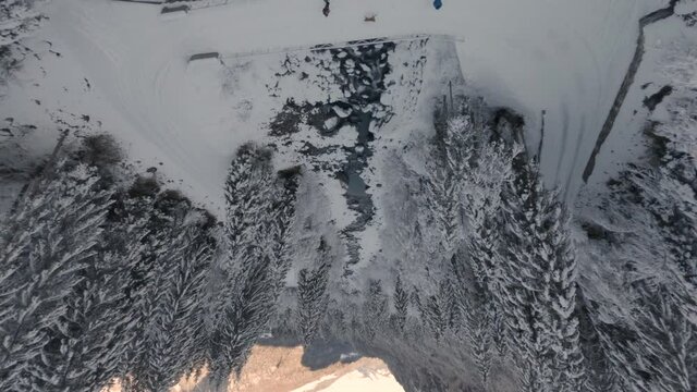 People Standing On Bridge Over River Near Cascade du Rouget In Winter.  - FPV, aerial 