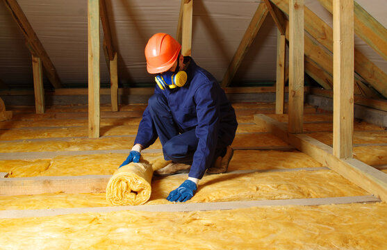 Worker insulate the attic with mineral wool