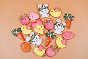 Closeup of variation of different Easter sugar cookies decorated with royal icing. Eggs, bunny, carrots and chicken on yellow background. Lovely sweet gift or postcard