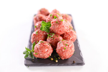 raw meatballs and herbs isolated on white background